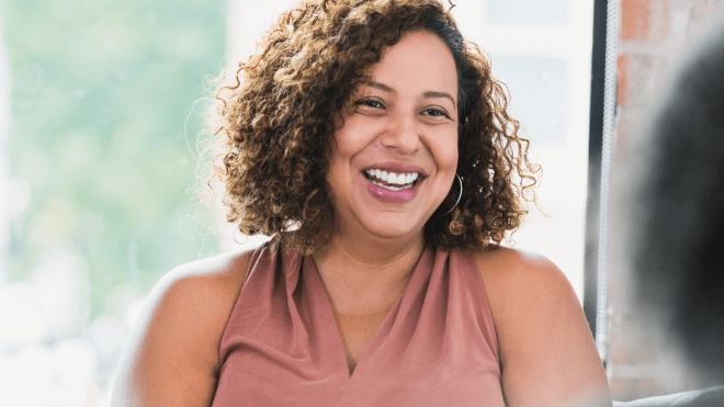 Woman smiling in conversation with another